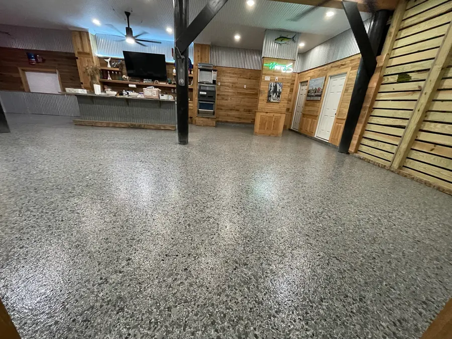 Flake-coated camp floor catching the light from the ceiling cans