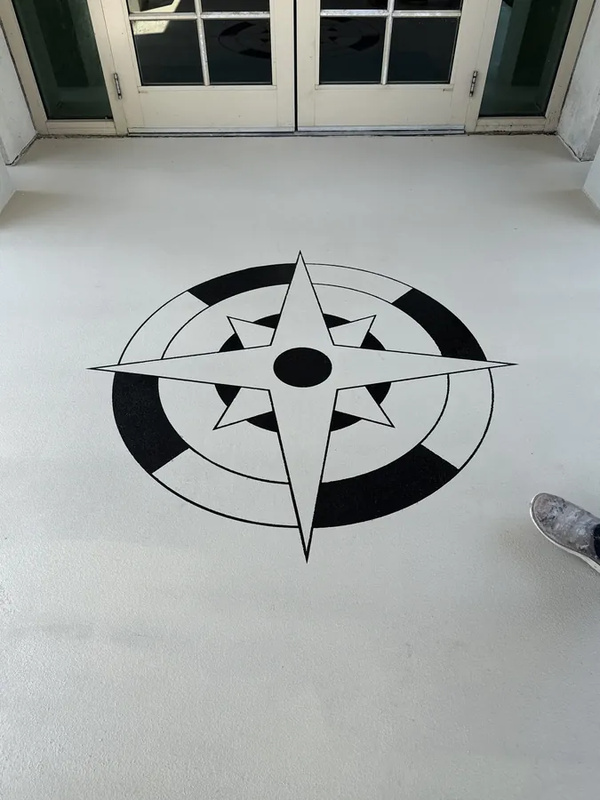Close-up of a hand-cut compass rose medallion in a finished concrete floor