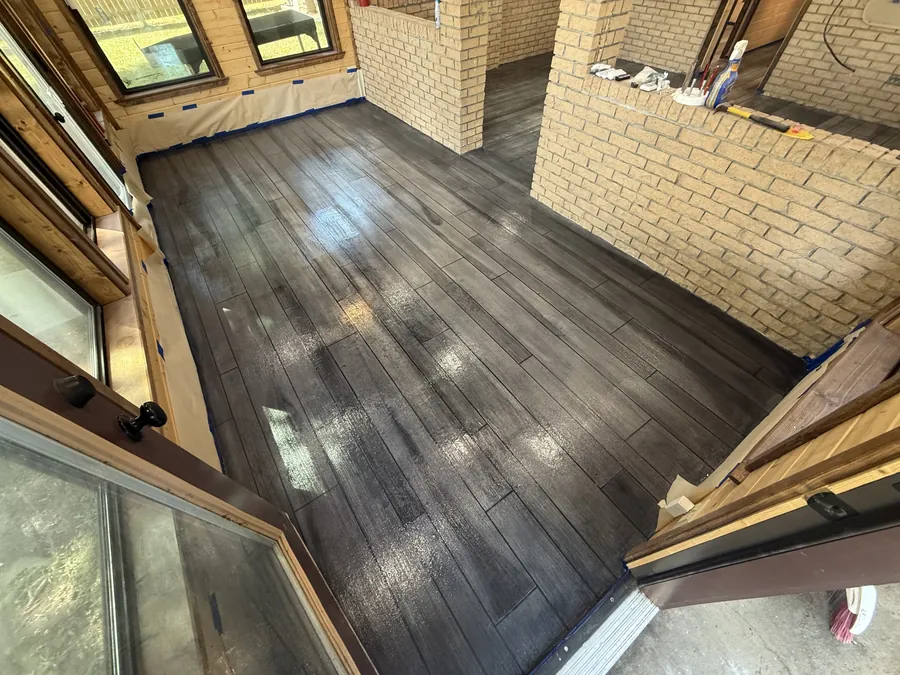 Charcoal wood plank overlay in a brick room with big windows