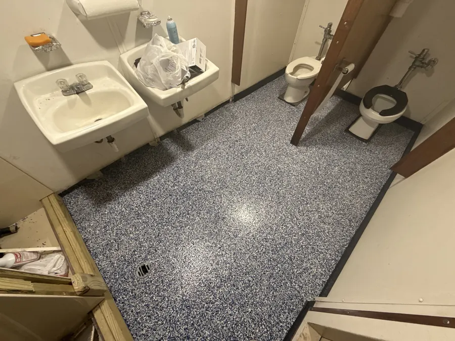 Blue and grey flake floor in a crew head aboard a vessel