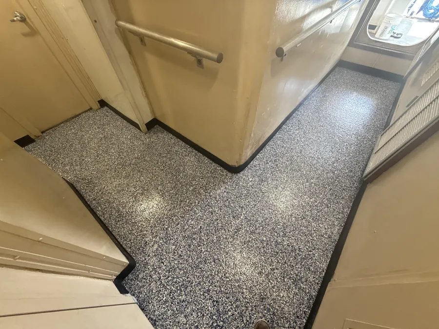 Flake flooring through a vessel hallway with handrails